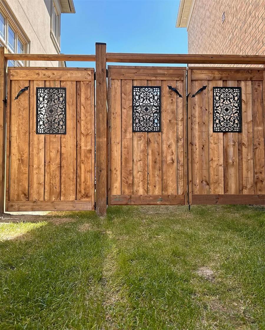Wide cedar double gate with decorative metal panels