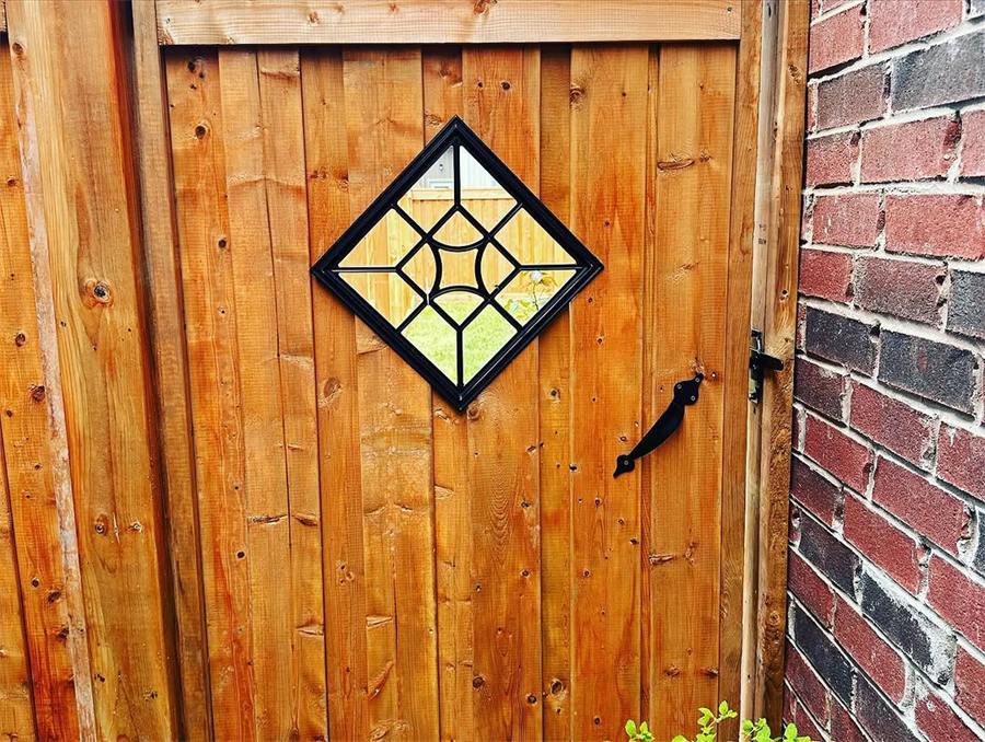 Cedar gate with a stained-glass diamond window
