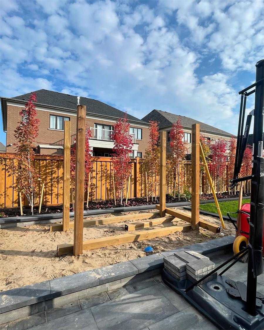 Pergola posts going up beside a new patio